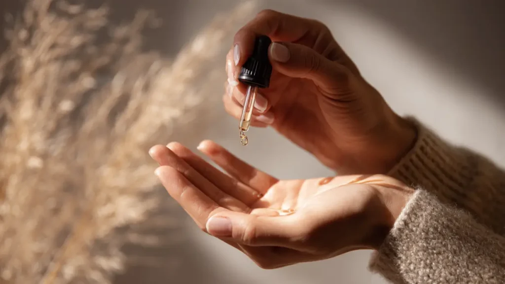 Χέρια με σταγονόμετρο serum — τελετουργία περιποίησης δέρματος SELUNA